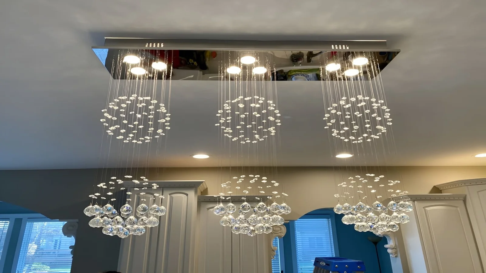 Three-cluster crystal pendant chandelier with LED lighting suspended from recessed ceiling frame