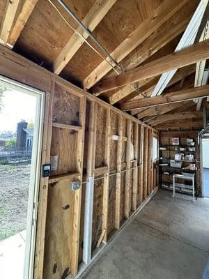 Electrical wiring and conduit installed in wooden stud framing during new construction rough-in phase