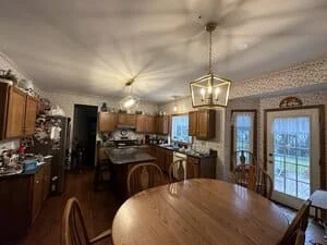 Kitchen dining area with pendant lights over island, recessed ceiling lights, and brass fixtures