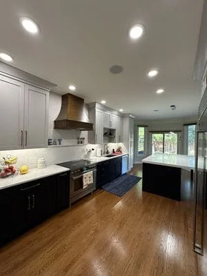 Recessed ceiling lights in modern kitchen with white and black cabinetry